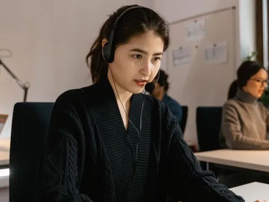 Dispatcher in a headset working at a laptop in an office